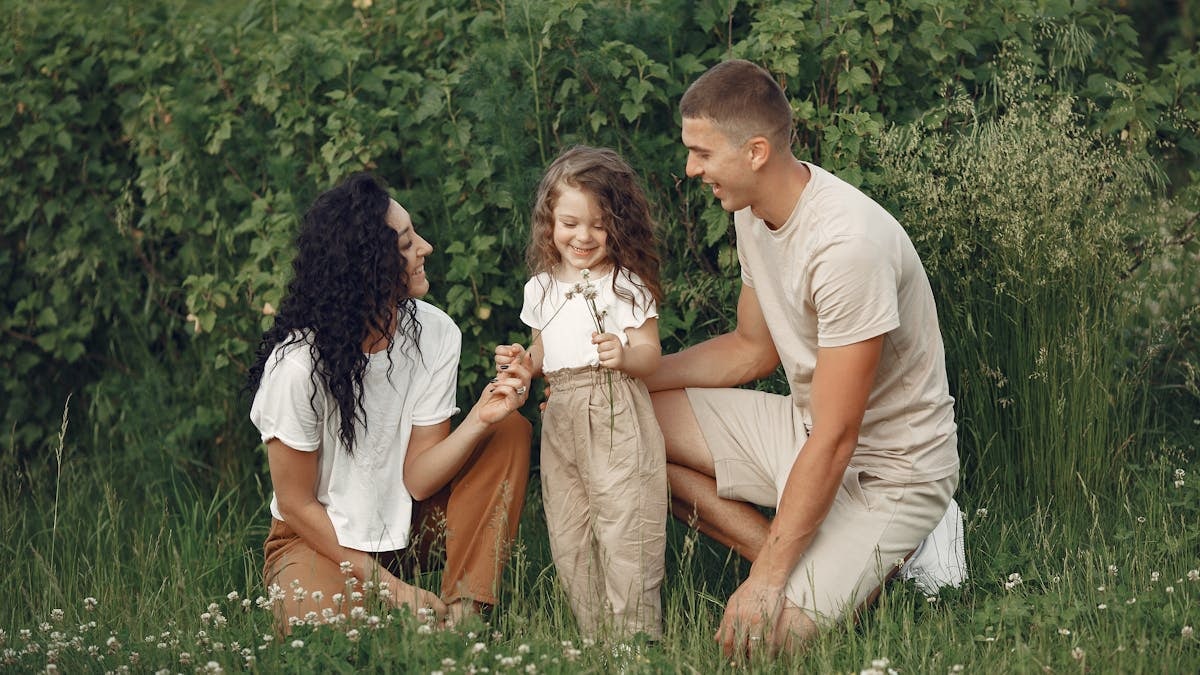 A joyful family enjoying time together in a lush green field.
